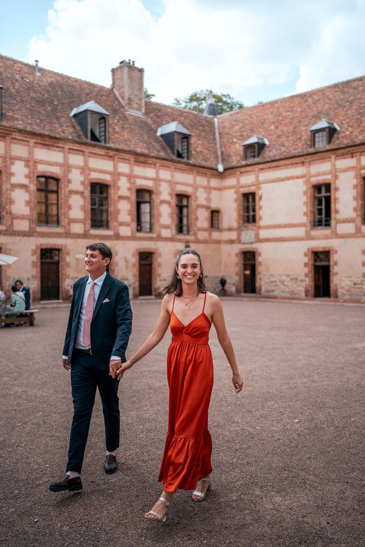 Les mariés marchent dans la cour du château