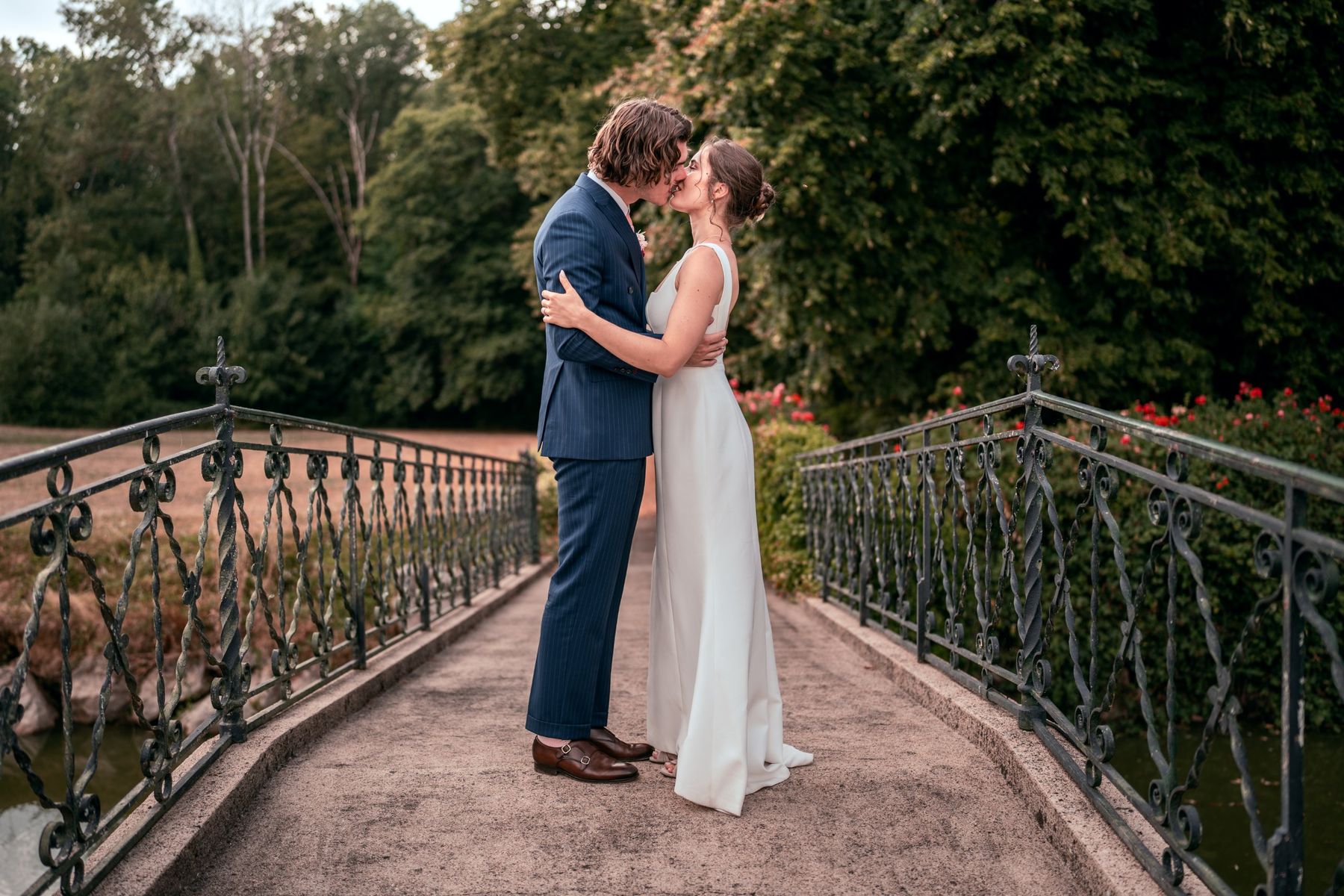 Baiser des mariés sur un pont en fer forgé